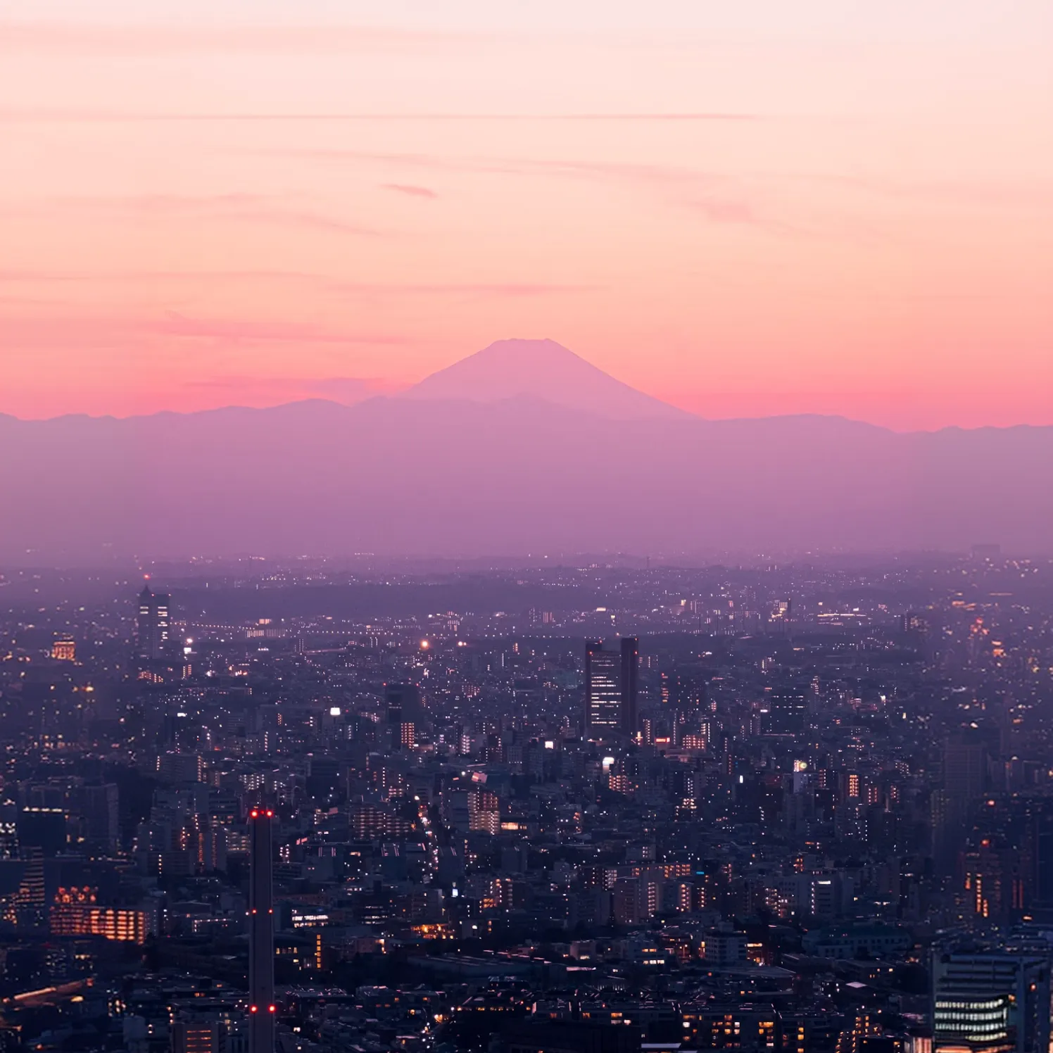 Mount Fuji at dusk above the lights of Tokyo