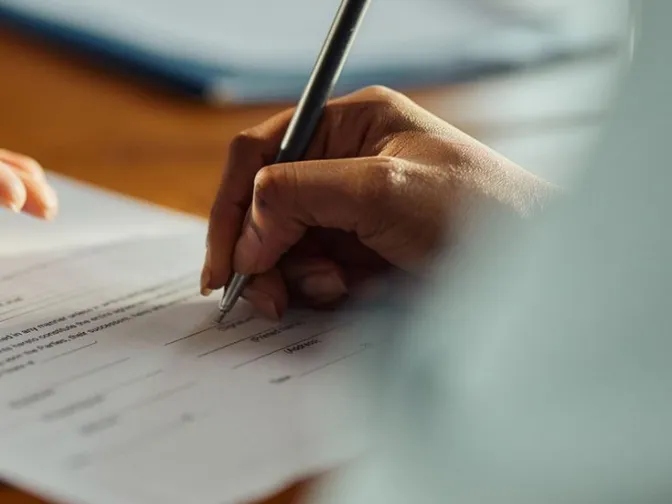 Hand signing a document with a fountain pen